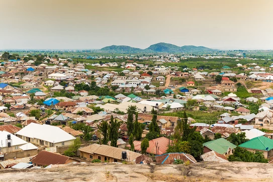 View from up high of homes crowded close together, with mountains in the distance