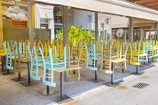 a photograph of a closed restaurant with chairs up on the tables