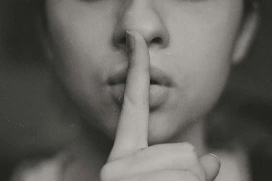 Grayscale photo of woman doing silent hand sign photo. Photo by Kristina Flour on Unsplash.