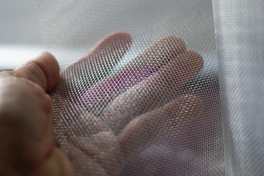 A person handles bed netting.